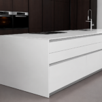 White Kitchen Island with an Integrated Stovetop and Sink in a Modern Dark wood Kitchen Setting