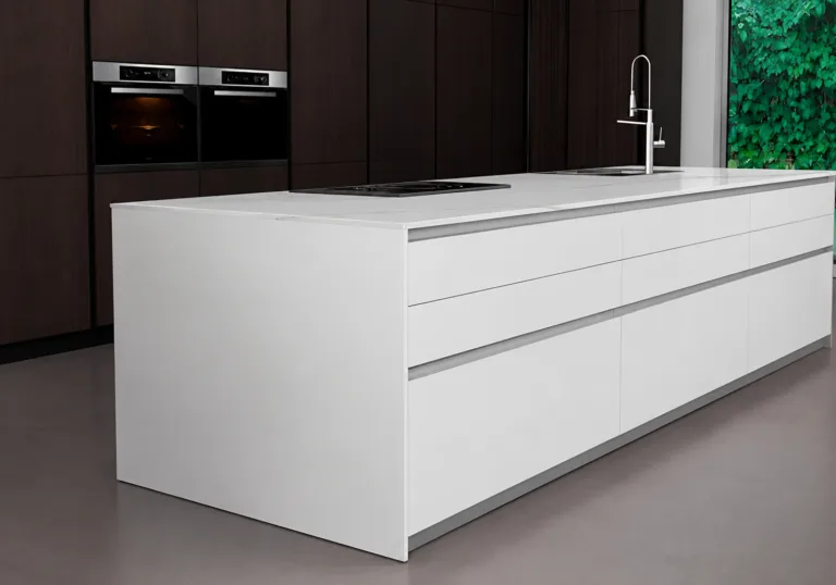 White kitchen island with an integrated stovetop and sink in a modern dark-wood kitchen setting