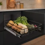 Open Pull out Drawer in a Modern Kitchen Filled with Fresh Vegetables Potatoes Onions Garlic Leafy Greens a Squash and a White Root Vegetable All on a Metal Rack