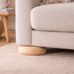 Untitled-1 | Securadeal Close up of a Beige Upholstered Sofa with a Round Wooden Leg Resting on a Light Carpet