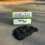 0be20b5f-0356-4d58-8eb7-505f97c17b1d | Securadeal Box Labeled Patchpal Pothole Solution on a Street with a Row of Black Circular Pothole Patches in Front