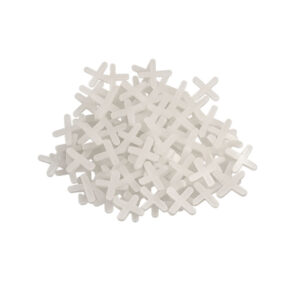 Pile of small white cross-shaped pieces scattered on a white background, like decorative sprinkles or chips